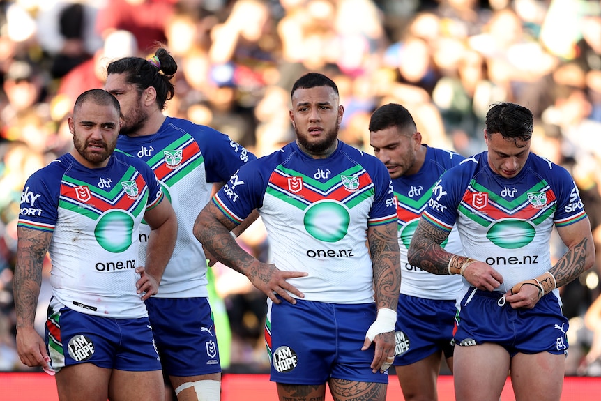 A group of rugby league players look upset after conceding a try 